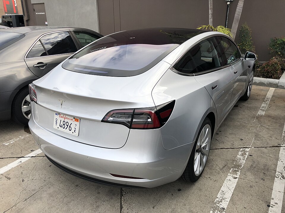 Silver Tesla Model 3, rear three-quarter exterior.