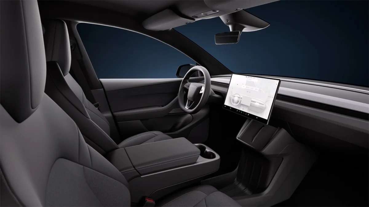 Tesla Model Y studio cabin with factory black headliner and dark pillars.