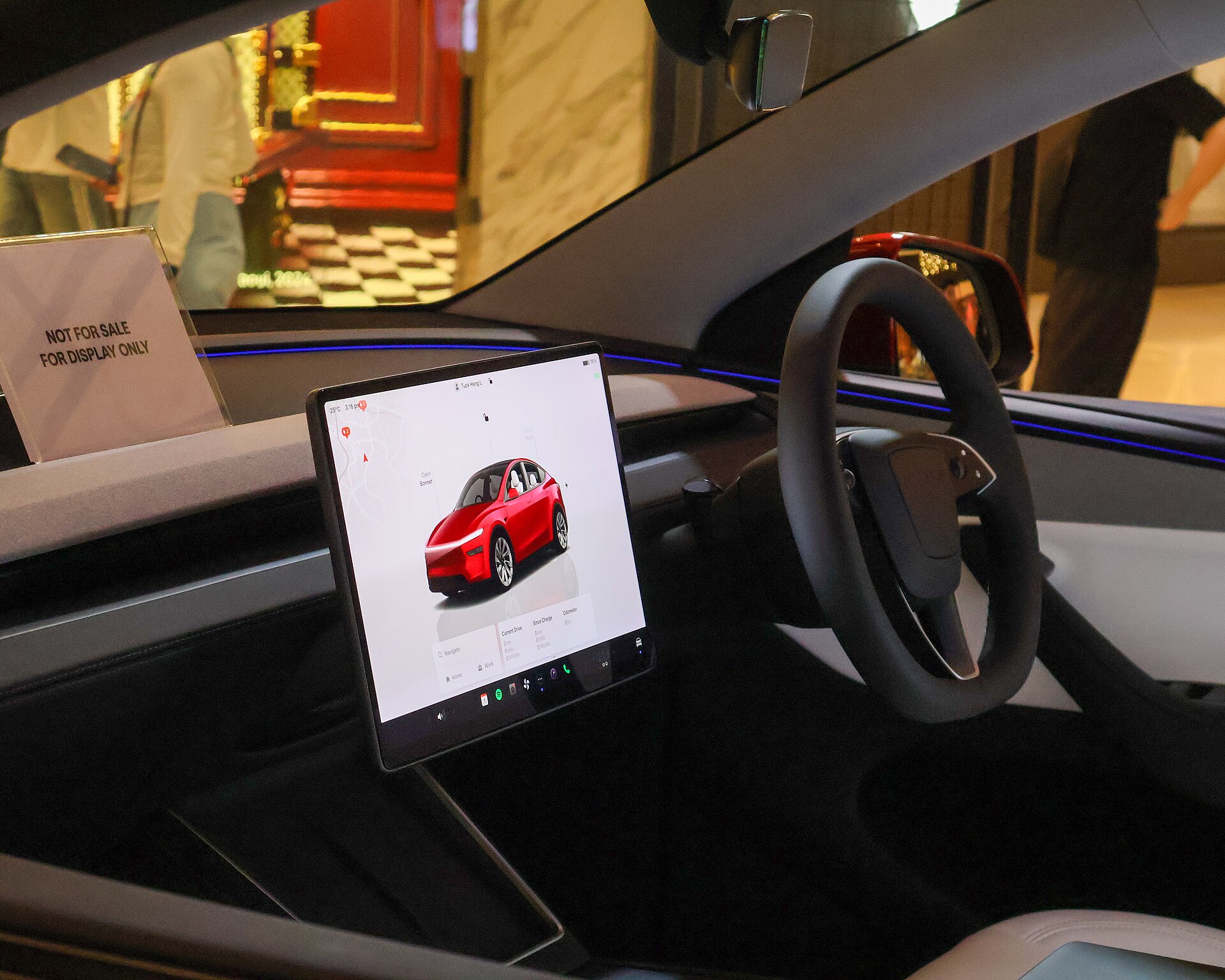 Tesla Model Y Juniper showcar cabin, black dash and steering wheel with white seat accents.