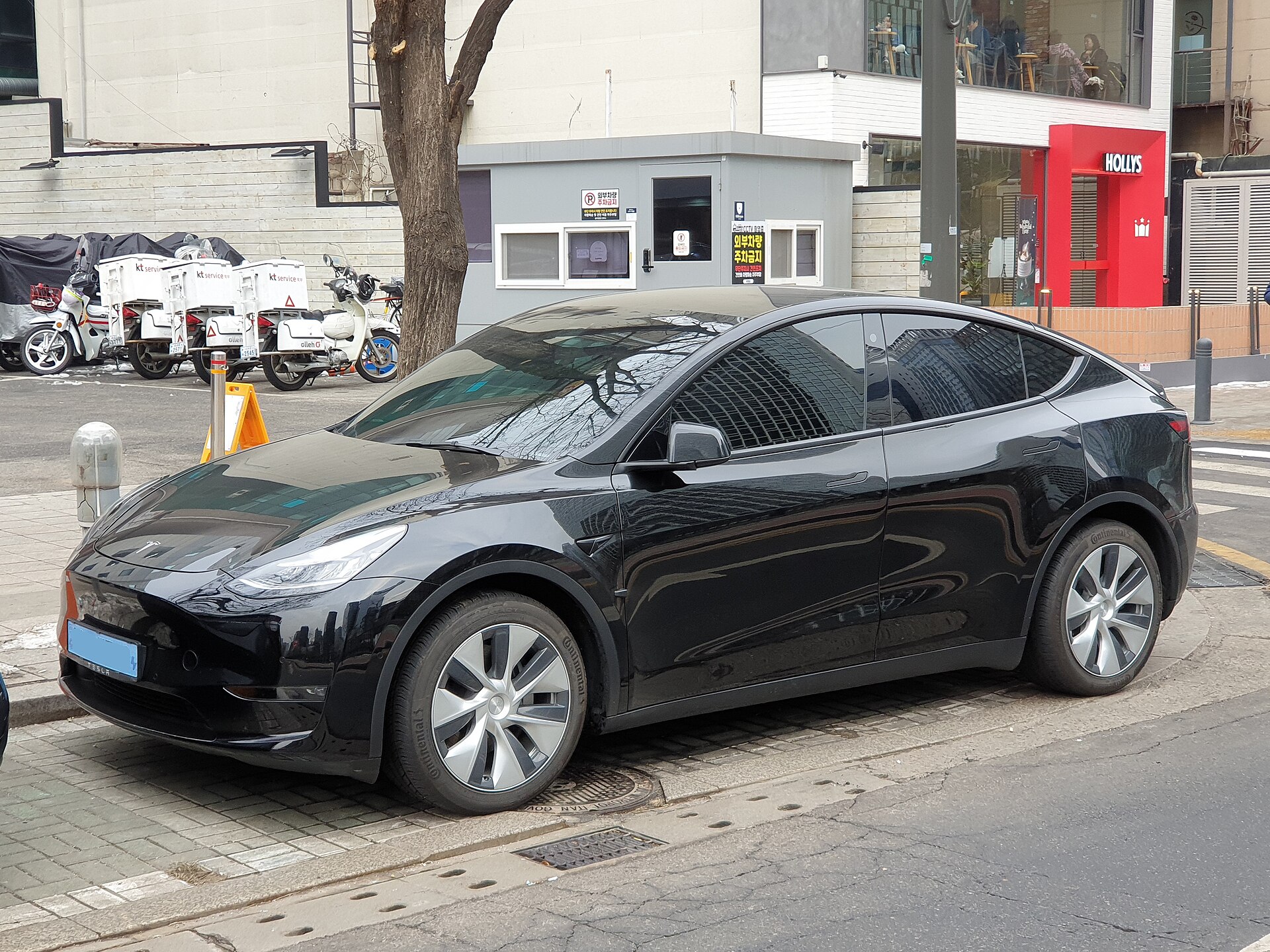 Solid Black Tesla Model Y Dual Motor, three-quarter front view on a city street.